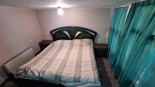 a small bedroom with a bed with blue curtains at Jūrmala beach in Jūrmala
