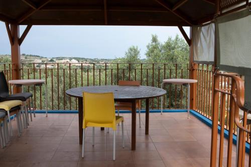 a table and chairs on a balcony with a view at Fun for all the family! in Żebbieħ
