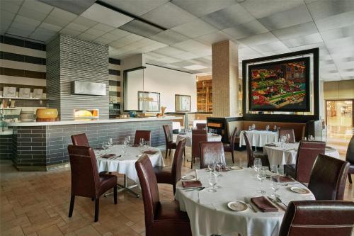 a restaurant with white tables and chairs and a bar at Signia by Hilton Orlando - An Official Walt Disney World Hotel in Orlando