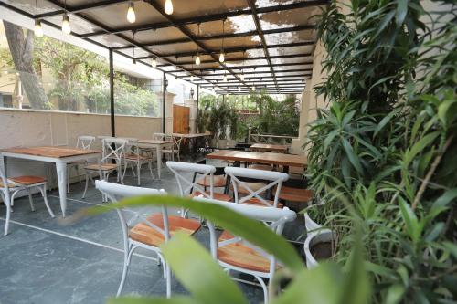 a restaurant with tables and chairs and plants at Grove Residency Hauz Khas Couple Friendly New Delhi in New Delhi
