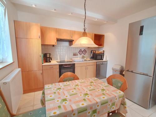 a kitchen with a table and a refrigerator at Nr 75 Holiday house Sigrid and Alfred in Gyenesdiás