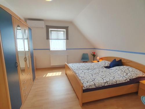 a bedroom with a bed with a blue head board at Nr 75 Holiday house Sigrid and Alfred in Gyenesdiás