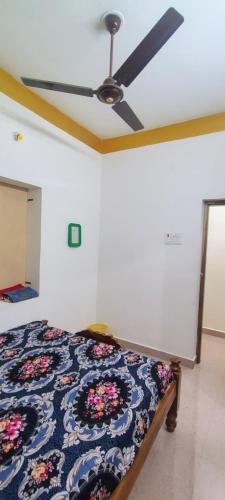 a bedroom with a bed with a ceiling fan at UmaNatarajan Residency in Tiruvannāmalai
