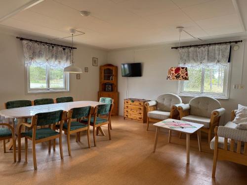 a living room with a dining room table and chairs at Åminne Fritid & Havsbad AB in Åminne