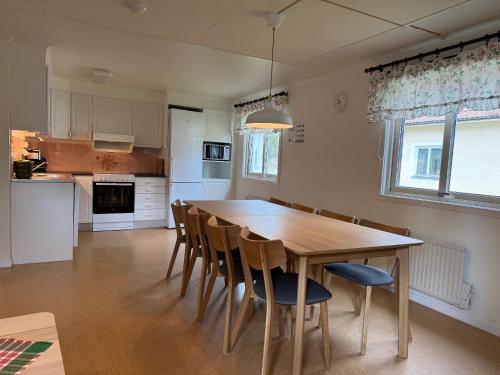 a kitchen and dining room with a wooden table and chairs at Åminne Fritid & Havsbad AB in Åminne