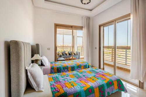 a bedroom with a bed and a large window at Grand Appartement de standing sécurisé, proche plage avec piscine privée in Bouznika