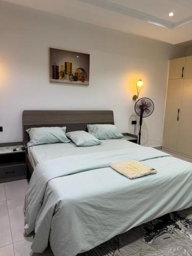 a bedroom with a large bed with a blanket at Precious Pavilion Apartment in Abuja