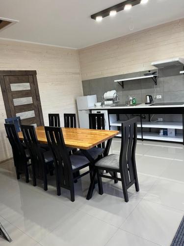 a kitchen with a wooden table and black chairs at Hotels mim in Vorokhta