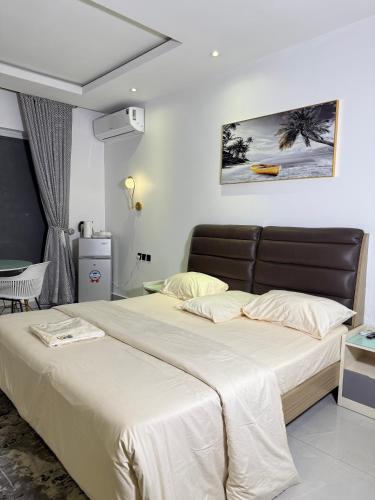a bedroom with a large bed with a black headboard at Precious Pavilion Apartment in Abuja