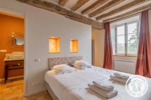 a bedroom with a large bed with towels on it at Gîte Apolise in Saint-Rémy-la-Varenne