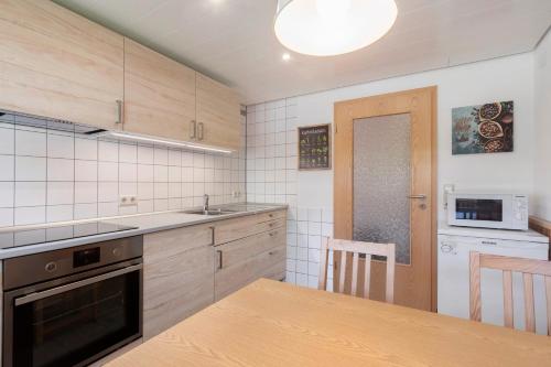 a kitchen with a table and a sink and a stove at Pension Birgit in Todtnauberg