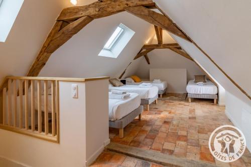 a attic room with four beds and a staircase at Gîte Apolise in Saint-Rémy-la-Varenne