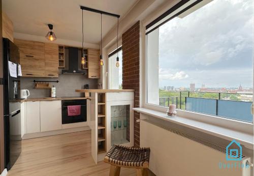 cocina con ventana grande y vistas a la ciudad en Postcard Apartment Scenic Escape 10 Minutes to Gdańsk Old Town and Seaside, en Gdansk