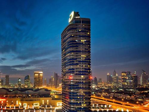 a tall building in a city at night at Damac Mall Street Residences in Dubai