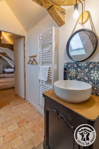 a bathroom with a sink and a mirror on a counter at Gîte Apolise in Saint-Rémy-la-Varenne