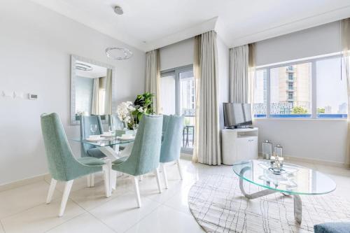 a living room with a table and chairs and a television at Damac Mall Street Residences in Dubai