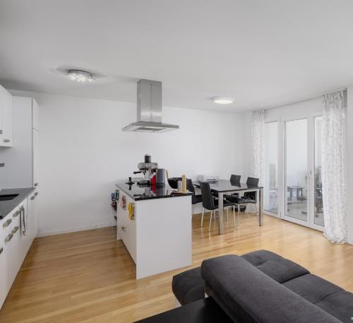 a white living room with a couch and a table at City Apartment in Opfikon