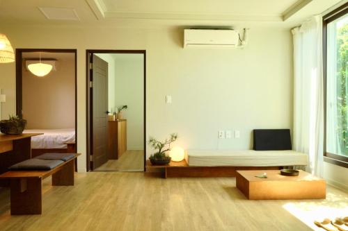 a living room with a bed and a table at Pyoseon Mansion in Seogwipo