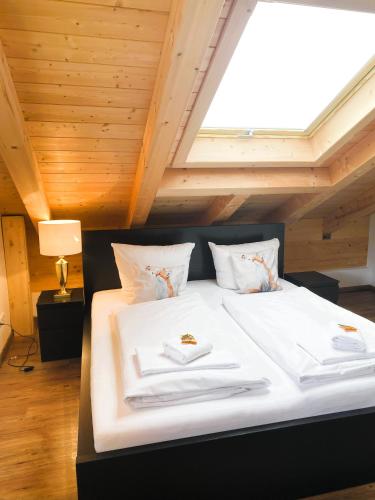 a bed with two towels on it in a room at FeWo Leni - Modernes Apartment mit Bergblick - Zentral gelegen in Mittenwald