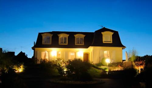 a large white house with lights on it at night at La Mansardière in Cancale