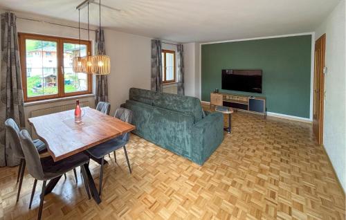ein Wohnzimmer mit einer grünen Couch und einem Tisch in der Unterkunft Lovely Apartment In Klösterle With Wifi in Klösterle am Arlberg
