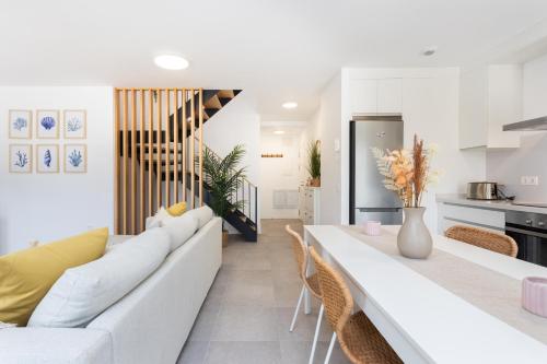 a living room with a white couch and a table at Home2Book Panoramic Sunset Terrace Escape in Guía de Isora