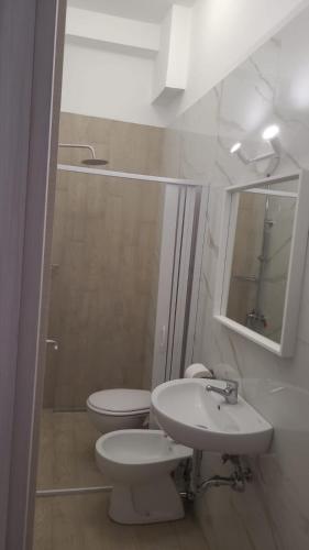 a white bathroom with a toilet and a sink at La Primavera in Palmi