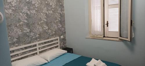 a small bedroom with a bed and a window at La Primavera in Palmi