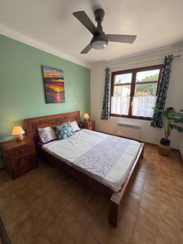 a bedroom with a bed and a ceiling fan at Détente au soleil in Sorède