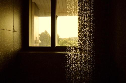a window in a bathroom with a shower curtain at Pyoseon Mansion in Seogwipo