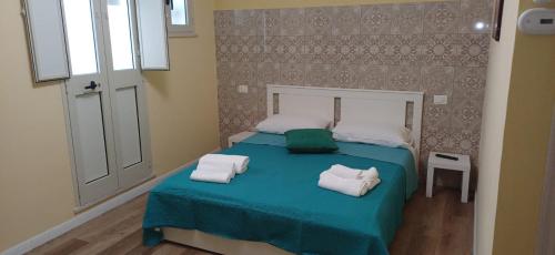 a bedroom with a blue bed with two pillows on it at La Primavera in Palmi