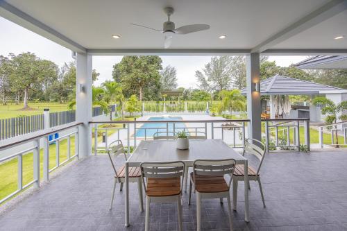 a patio with a table and chairs and a pool at ThaiLife Wellness & Meditation Resort- SHA Plus in Khao Lak