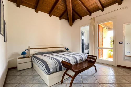 una camera da letto con un letto, una sedia e una finestra di LuxRent Villa Smeralda Pool and Beach a Capo Coda Cavallo
