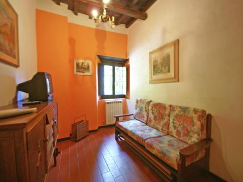a living room with a couch and a tv at Farmhouse in Dicomano with Tuscan Views in Dicomano