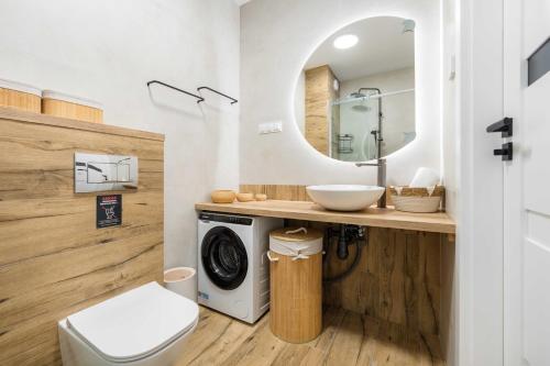a bathroom with a washing machine and a sink at Dolina Szczęścia Apartamenty Pine - Dream Apart in Szklarska Poręba