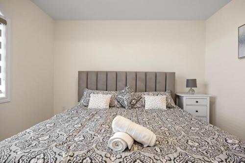 a bedroom with a large bed with a gray and white bedspread at Cozy Comfort Escape - Your Next Memorable Retreat in Brampton