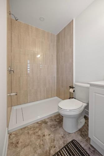 a bathroom with a toilet and a tub and a shower at Cozy Comfort Escape - Your Next Memorable Retreat in Brampton