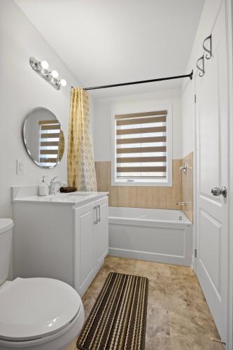 a bathroom with a toilet and a tub and a sink at Cozy Comfort Escape - Your Next Memorable Retreat in Brampton