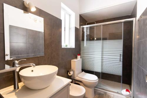 a bathroom with a white sink and a toilet at Apartamento acogedor con Piscina en Tenerife in Icor