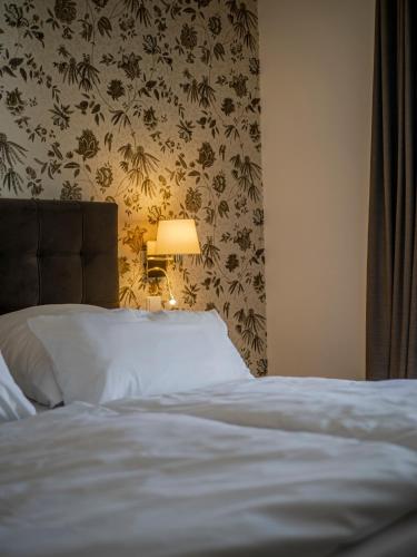 a bedroom with a bed with a lamp next to it at Boutiquehotel Seiler Hof Keitum in Keitum