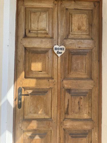 Una puerta de madera con un cartel en Leo home, en Aosta