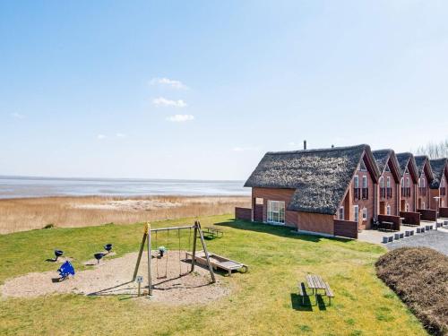 a building with a playground next to the beach at Seaside Haven in Vadehavet - By Traum Ferienwohnungen in Bolilmark
