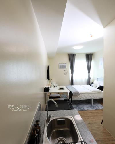 a kitchen with a sink and a room with a bed at RYS & Shine in Silang