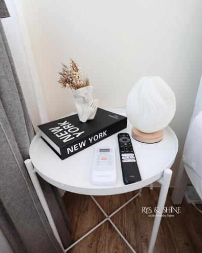 a small white table with a book and a remote control at RYS & Shine in Silang