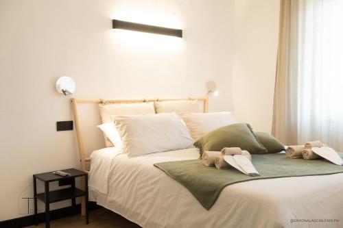 a bed with two stuffed animals sitting on it at Turchetti's Rooms in Porto Ercole