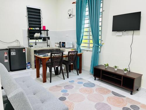 a living room with a table and a tv at Zara Homestay Tok Bok in Machang