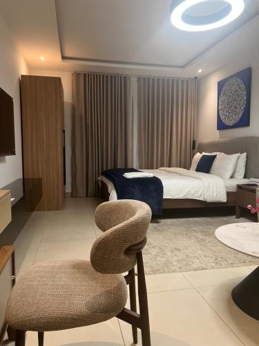 a bedroom with a bed and a chair in it at Belrose Place in Accra