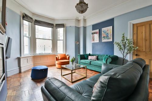 a living room with a couch and a table at Elegant Victorian Home with Pool Table & Parking in Cardiff