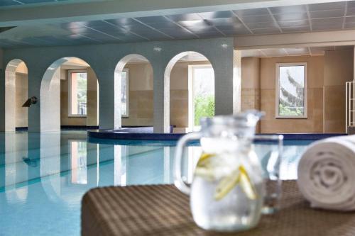a glass jar with a banana in it next to a swimming pool at Renaissance Tuscany Il Ciocco Resort & Spa in Barga
