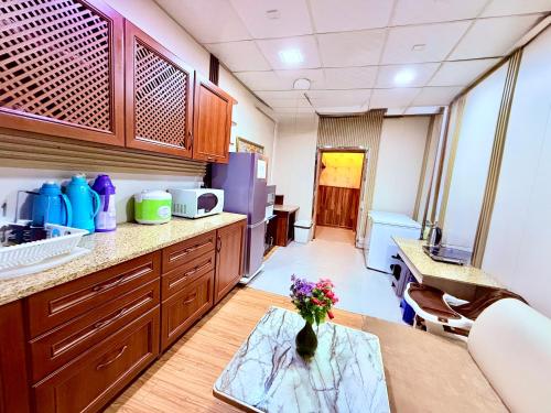 a kitchen with wooden cabinets and a vase of flowers on a table at City Hostel & Tours in Ulaanbaatar